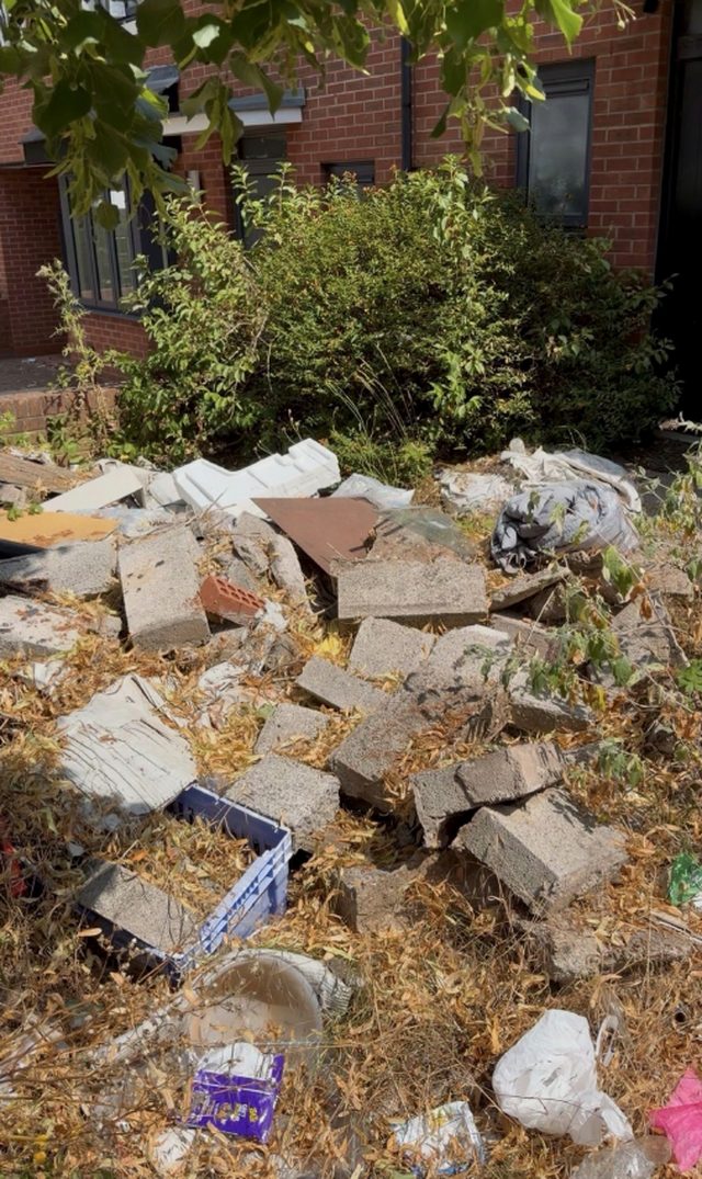 A front garden before clearance, covered in rubble and debris